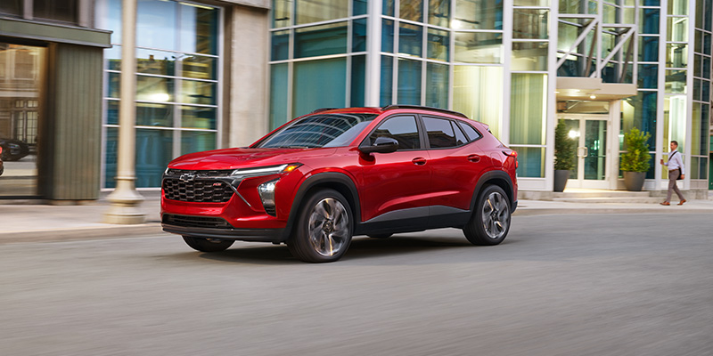 Silver Chevrolet Trax parked on a city street near a brick building, angled view showing front and side