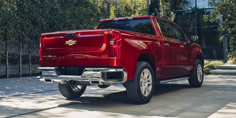 Red Chevrolet Silverado 1500 pickup truck parked in an urban setting.

